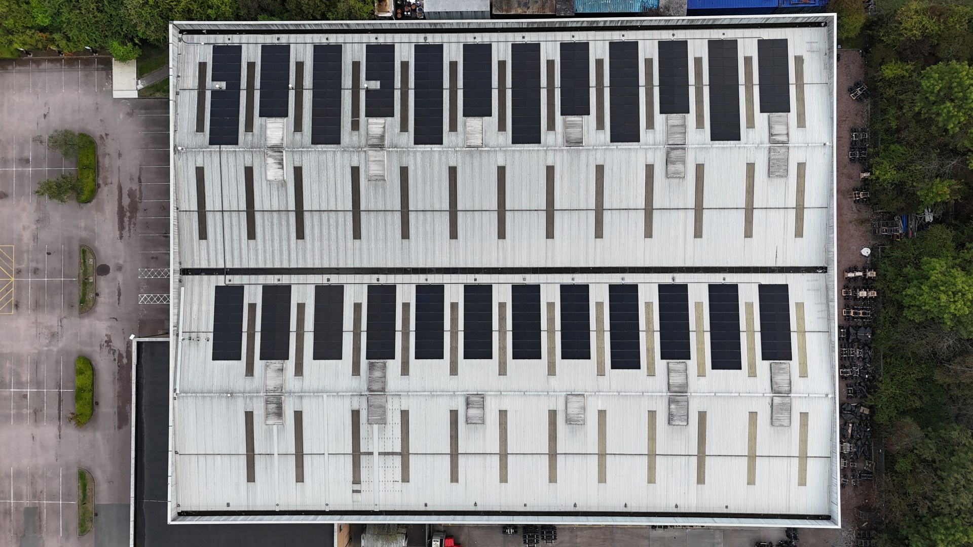 Industrial roof with solar panels photographed from above by JB Motion
